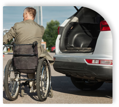 Pessoa cadeirante ao lado de um carro